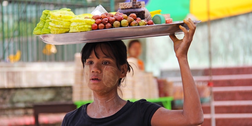 a young vendor with fruits on her head pic