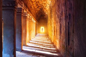 a-monk-walking-in-the-passageway-of-angkor-wat